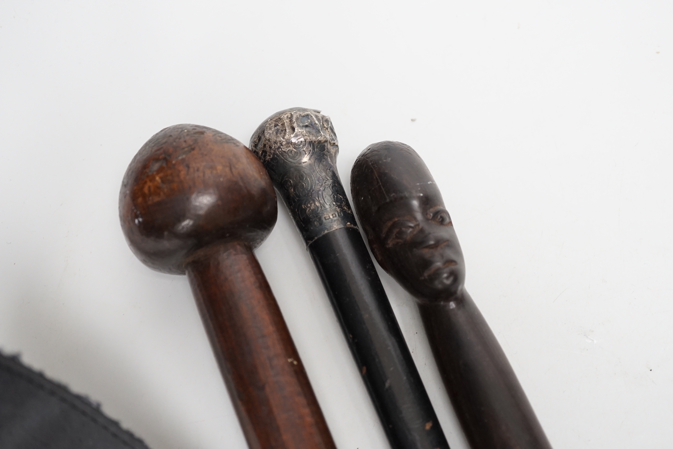 A silver topped walking cane and two African carved wood canes